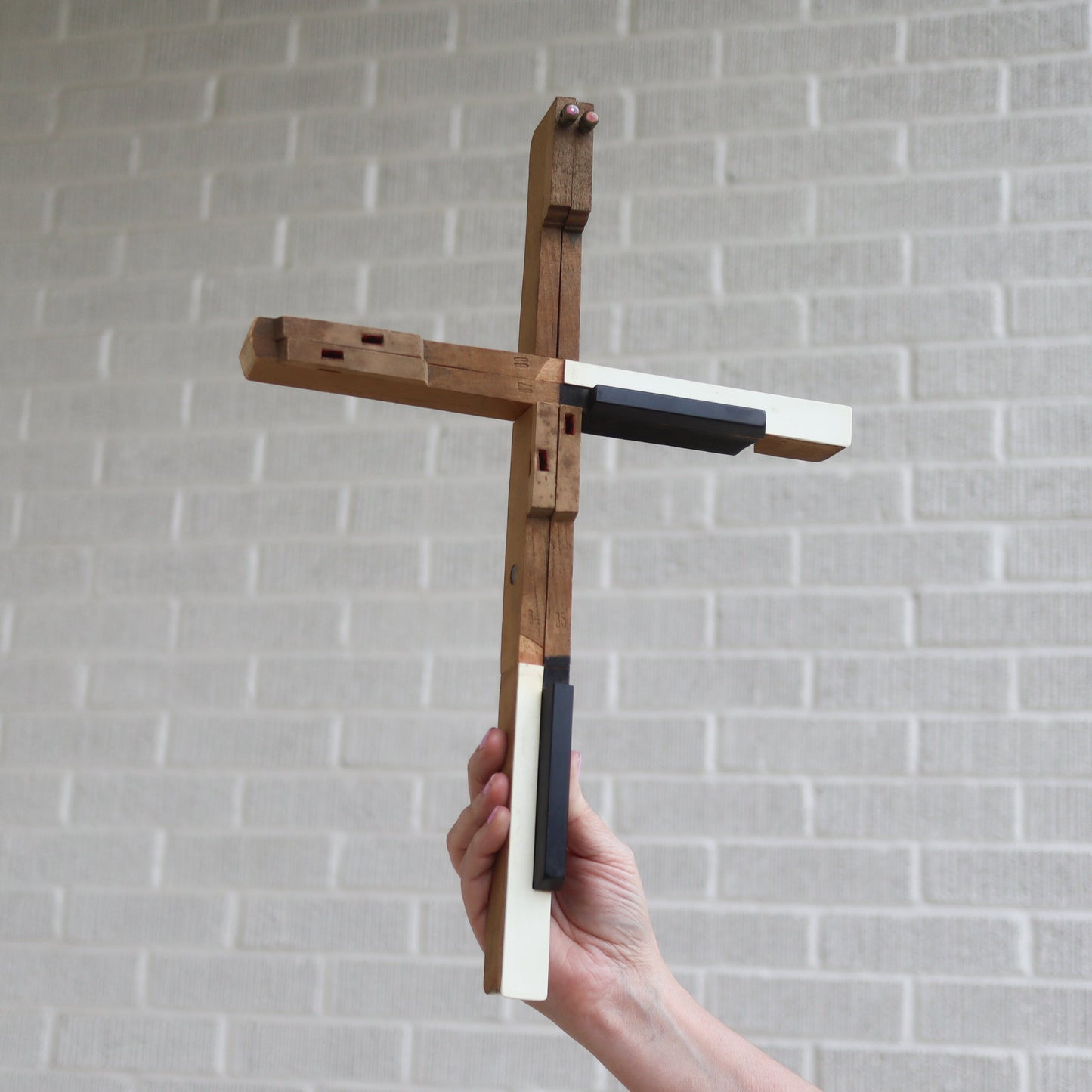 Wooden piano key cross by Dennehey Design Co., handcrafted cross featuring piano key design, suitable for religious or decorative use.