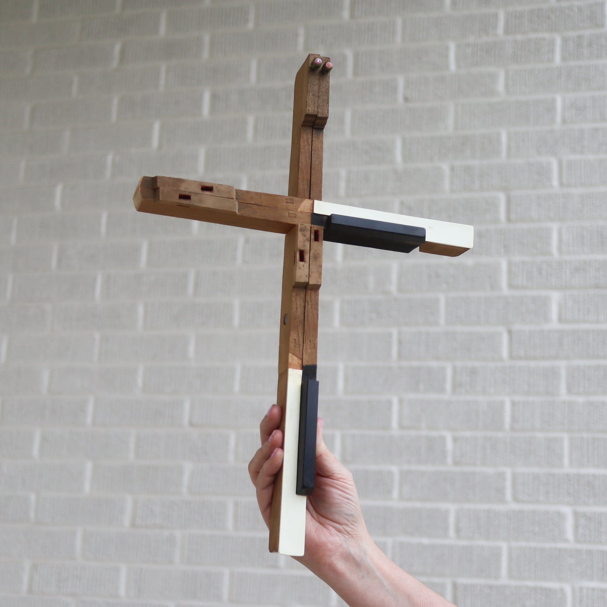 Wooden piano key cross by Dennehey Design Co., handcrafted cross featuring piano key design, suitable for religious or decorative use.