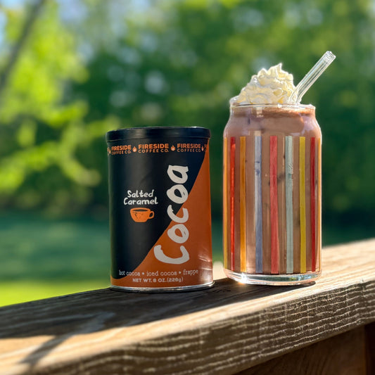 Fireside Coffee Co. salted caramel cocoa in a mug with whipped cream and caramel drizzle, steaming hot and ready to enjoy.