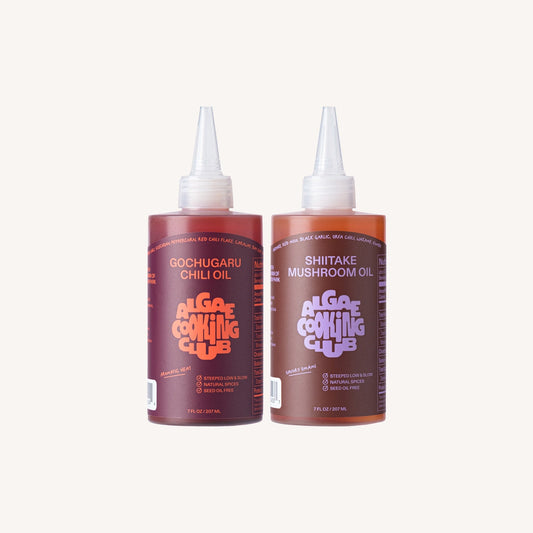 Algae Cooking Club infused oil duo featuring two bottles of flavorful herbal-infused cooking oils in elegant glass bottles.
