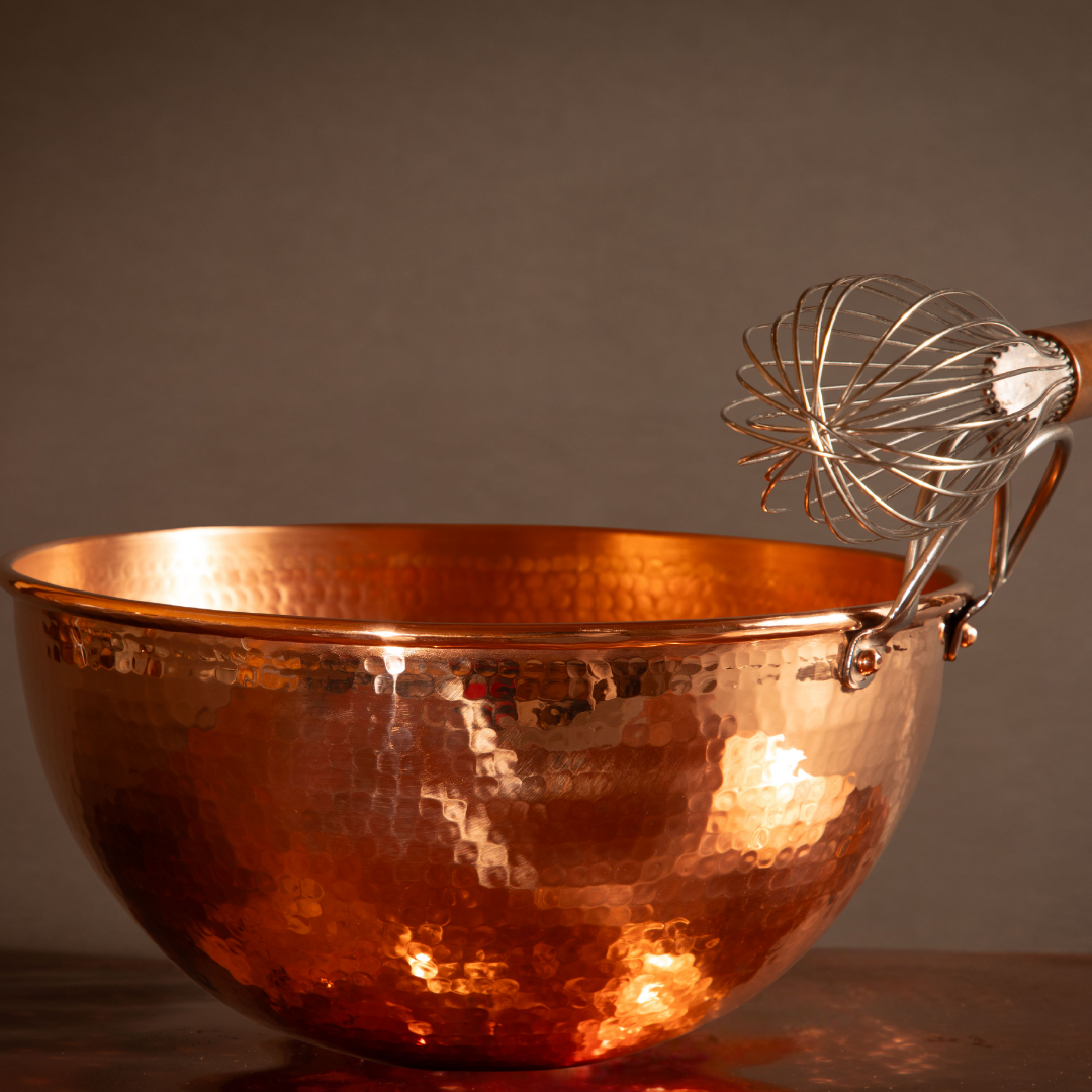 Set of Sertodo copper mixing bowls with a whisk inside, showcasing shiny, polished copper surface and versatile kitchen tools.