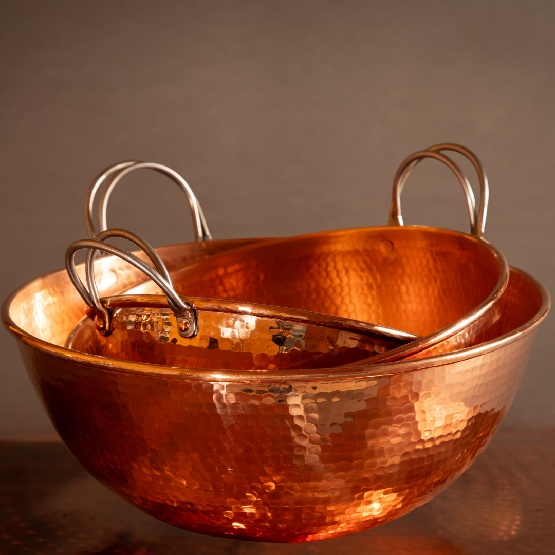 Set of Sertodo copper mixing bowls, shiny and polished, stacked together for baking and kitchen prep.