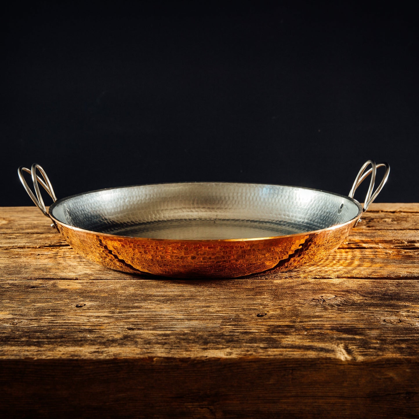 Alicante Copper Paella Pan by Sertodo, large round cookware with copper surface and handles, ideal for cooking authentic paella.
