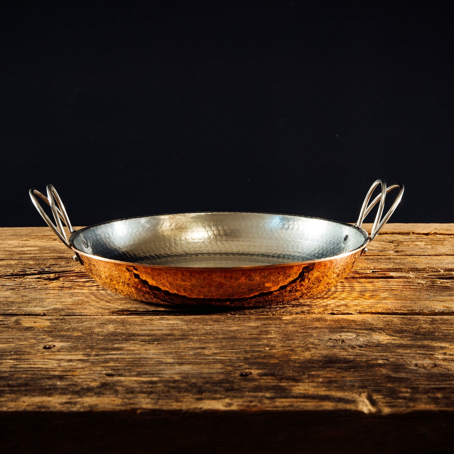 Alicante copper paella pan by Sertodo with wooden handles, round shallow pan for preparing traditional Spanish paella.