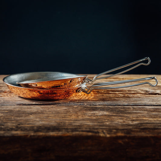 Two Sertodo copper skillets, 10-inch and 8-inch, shown with polished copper surfaces and sturdy handles.