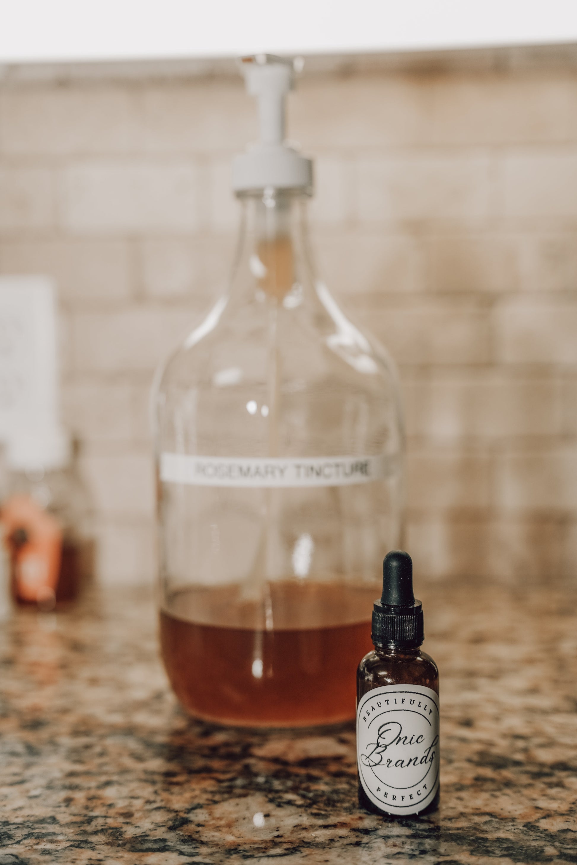 Onic Brands Elemental Rosemary Tincture bottle with dropper, herbal supplement in a glass container, on a neutral background.