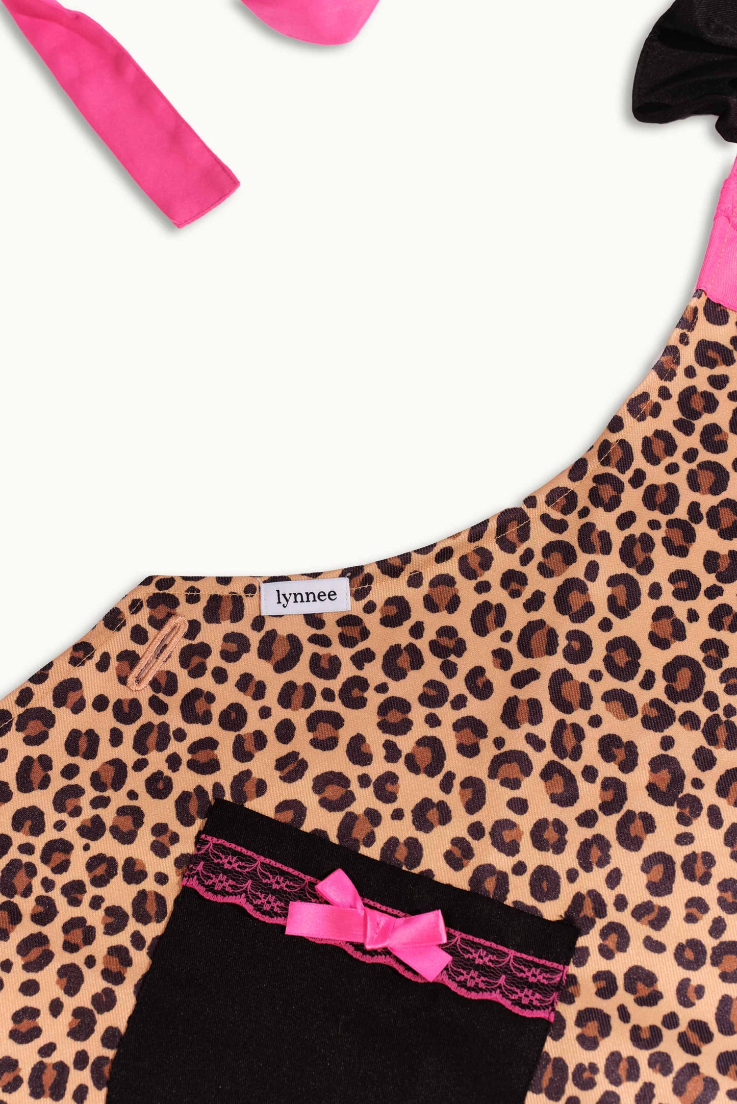 Pink leopard Lynnee apron with adjustable straps, featuring a bold leopard print design, perfect for cooking or baking.