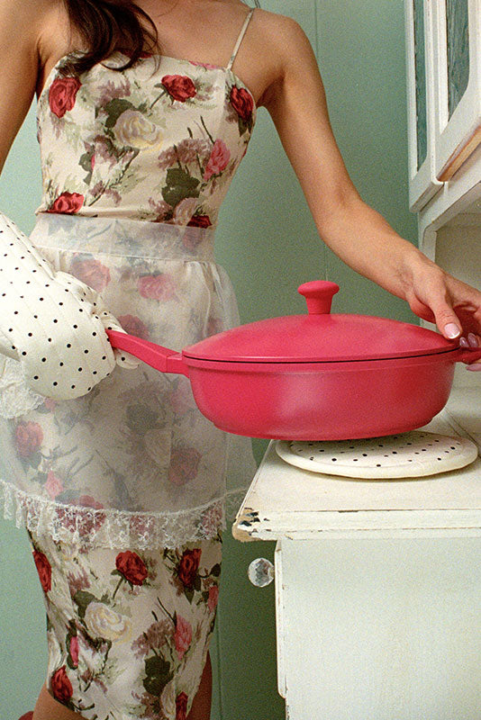 Pink 11-inch frying pan by Lynnee shown with a black handle and non-stick surface in a lifestyle kitchen setting.