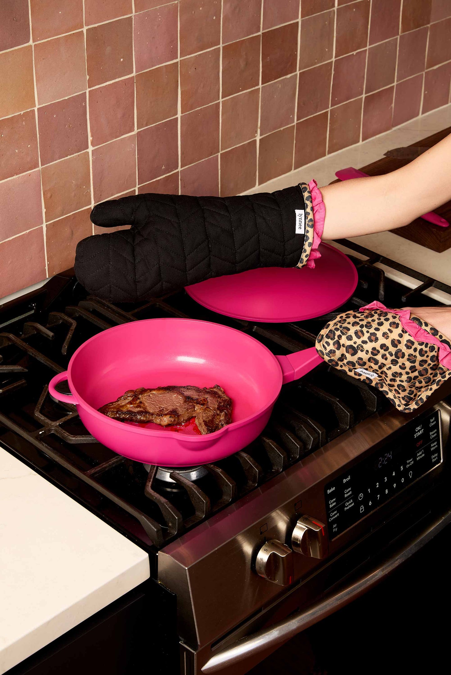 Lynnee oven mitt and pot holder set in hot pink leopard print, designed for safe handling of hot cookware in the kitchen.