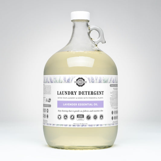 Rustic Strength Laundry Detergent | Lavender comes in a clear gallon jug with handle, white cap, white label featuring lavender illustrations and Lavender Essential Oil text. Contains light yellow hypoallergenic, biodegradable detergent.
