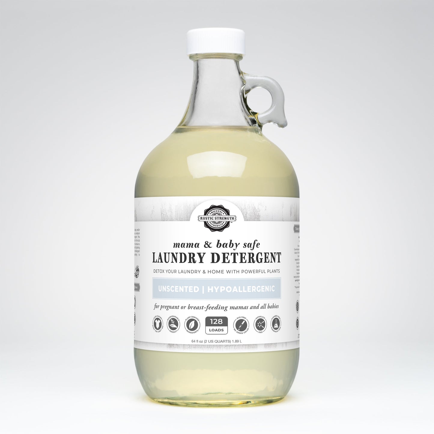 A clear glass bottle with a handle, filled with light yellow liquid, labeled Rustic Strength Laundry Detergent | Mama + Baby Safe—unscented, hypoallergenic, and safe for pregnant or breastfeeding women and babies.
