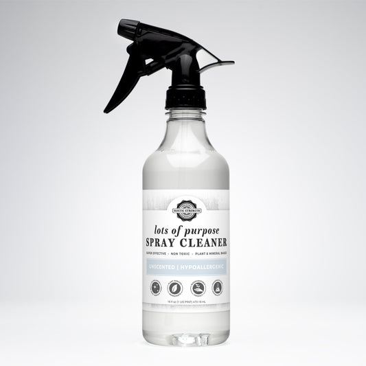 The Rustic Strength Lots of Purpose Spray Cleaner | Unscented comes in a clear bottle with a black spray nozzle and white label, highlighting its plant & mineral-based, non-toxic, hypoallergenic formula thats safe for everyday multi-surface use.