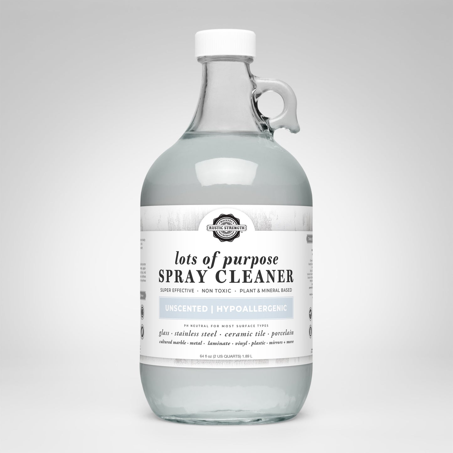 A clear glass bottle with a handle labeled Lots of Purpose Spray Cleaner | Unscented by Rustic Strength. This plant-based, hypoallergenic, toxin-free spray is unscented and safe for use on multiple surfaces.