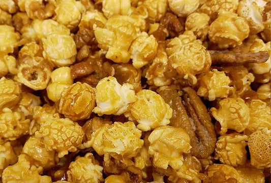 Millican Pecan caramel pecan popcorn in a 12oz bag with golden caramel coating and roasted pecans, ready for snacking.