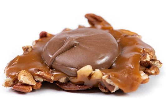 Milk chocolate Caramillicans pecan treats by Millican Pecan, showing individually wrapped pecan-filled chocolates with smooth milk chocolate coating.