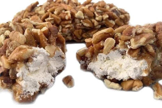 Millican Pecan Log Rolls, pecan treats with rolled pastry and pecan filling, displayed on a wooden surface.