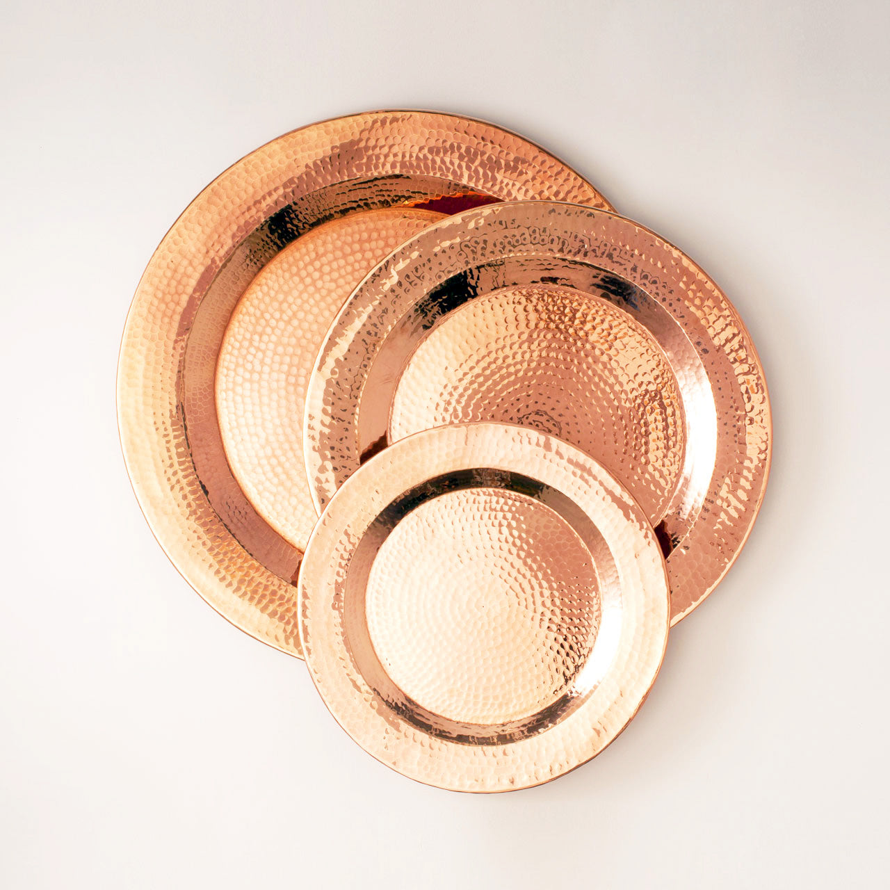 Set of copper Thessaly round platters by Sertodo, featuring polished, handcrafted serving plates with a smooth, reflective finish.