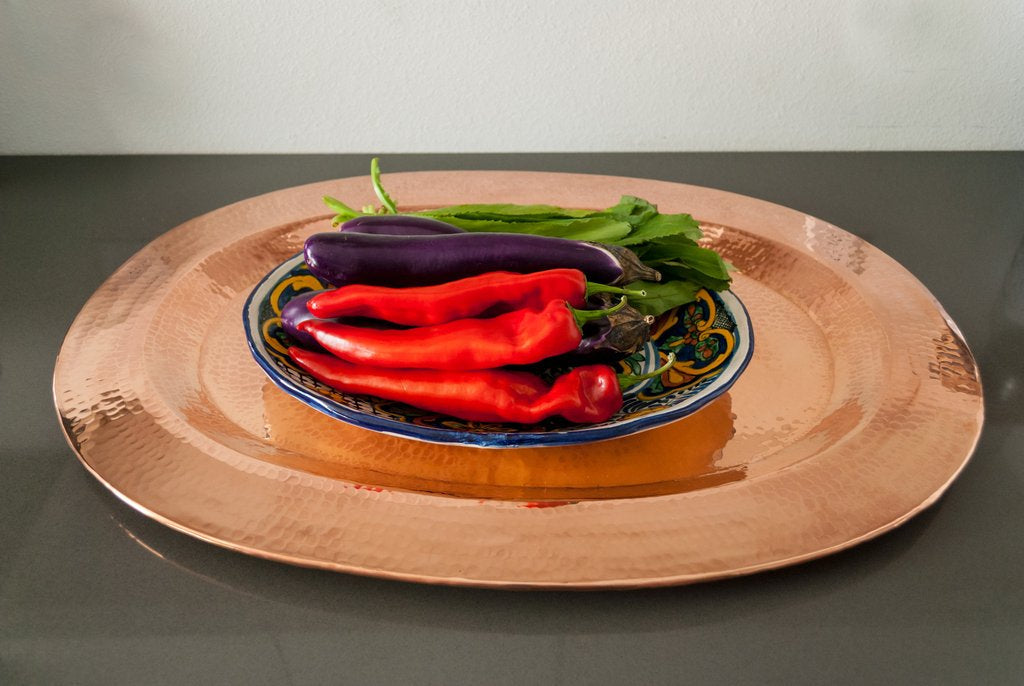 Oval copper platter from Sertodo's Thessaly collection, showcasing a polished, reflective surface perfect for serving dishes.