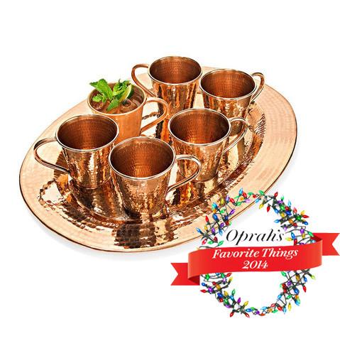 Sertodo Thessaly oval copper platter with six matching plates, shiny finish, ideal for serving food in a stylish dinner setting.
