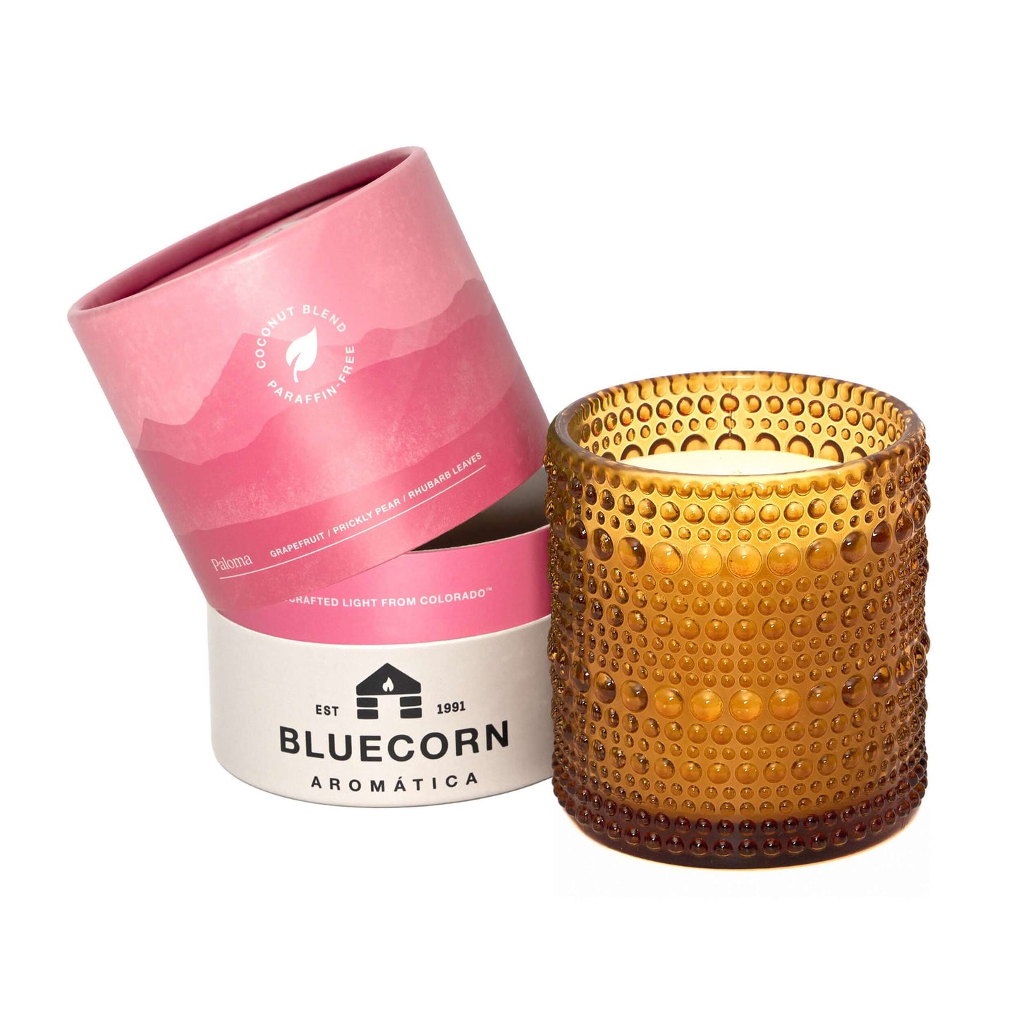 Bluecorn Candles Paloma scented candle in clear glass container, showcasing elegant glassware and warm candle glow.