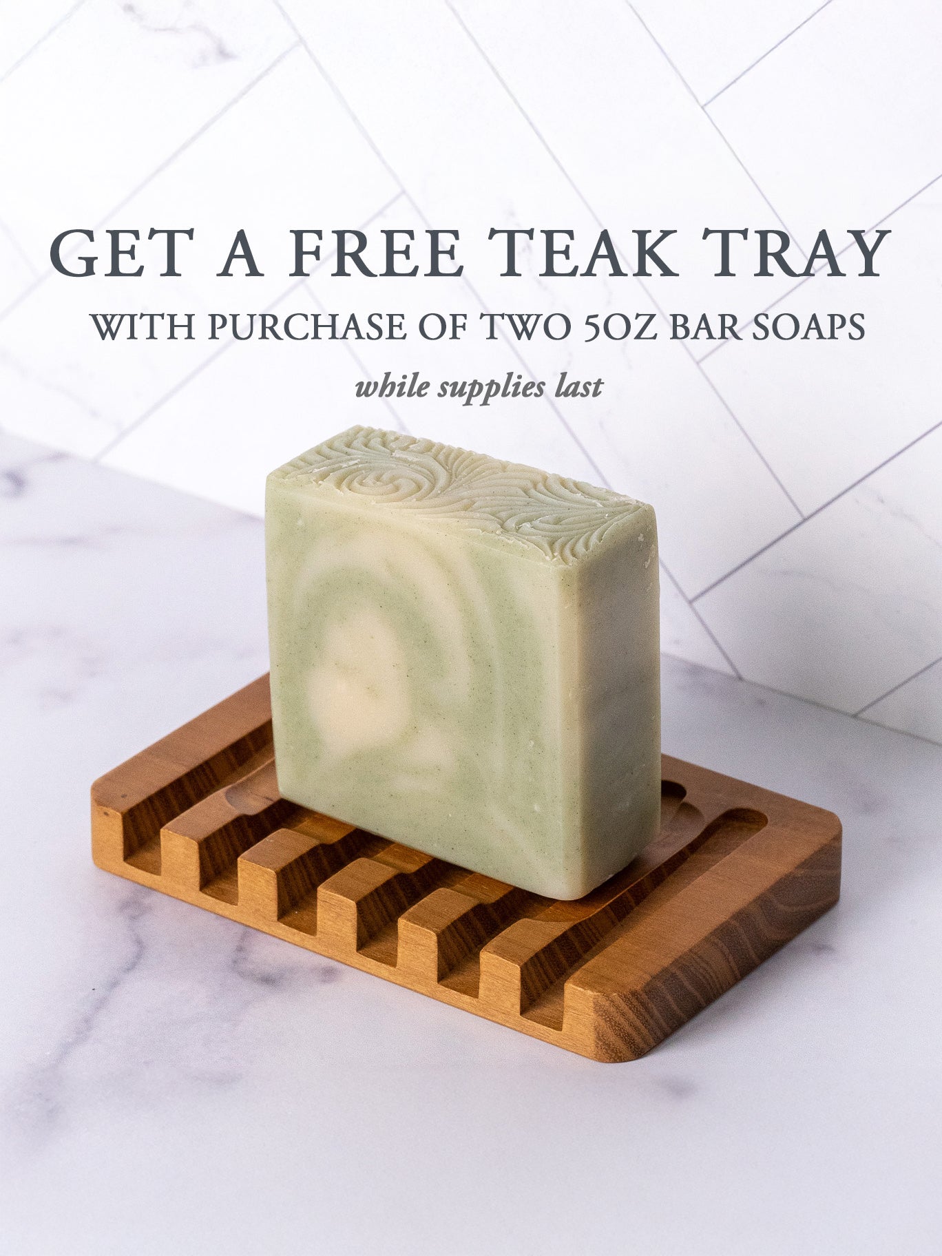A Rustic Strength Bar Soap | Peppermint Tea Tree sits on a teak tray. Text above: Get a free teak tray with purchase of two 5oz bar soaps while supplies last. White tile background.