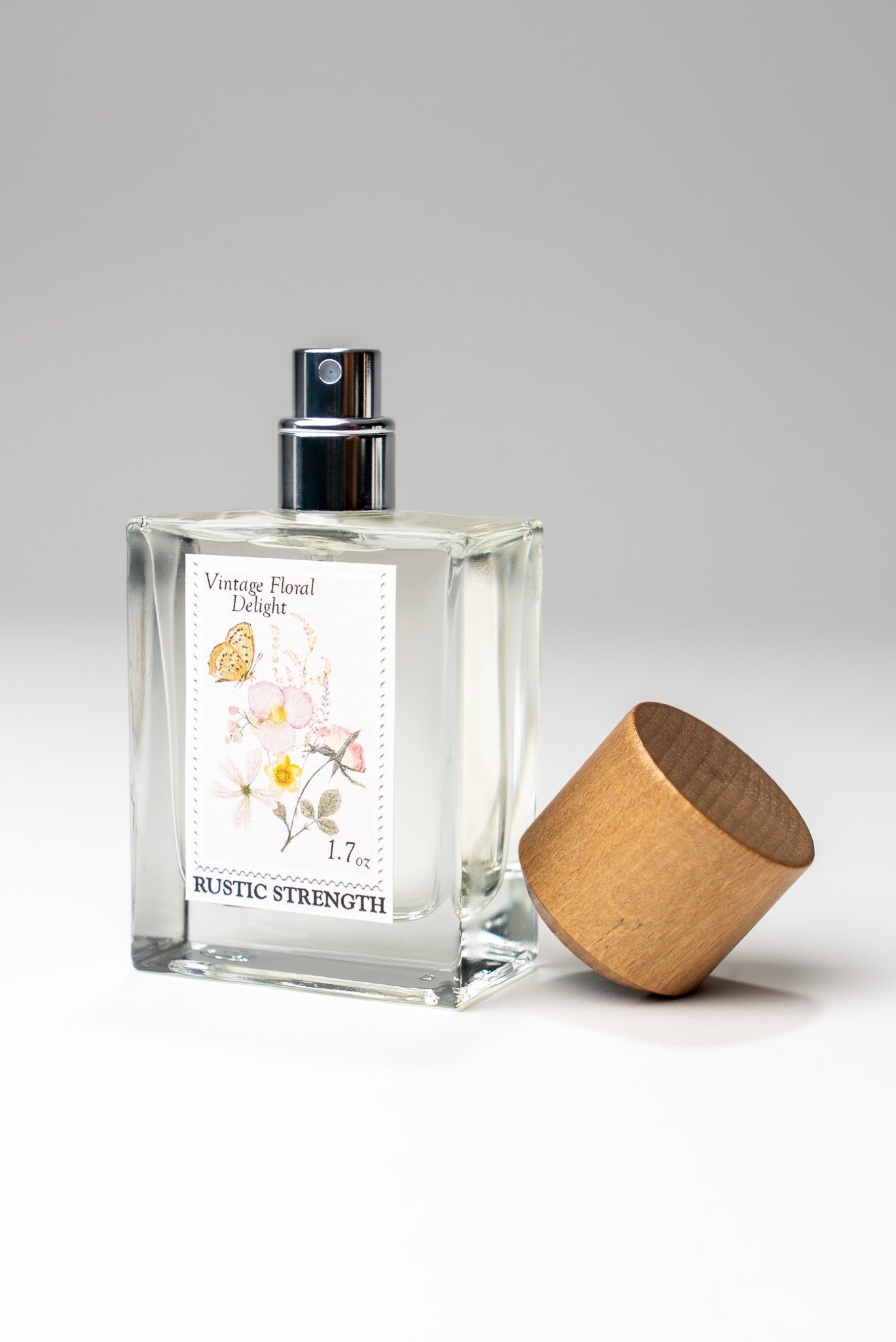 Rustic Strength Vintage Floral Delight perfume bottle, 1.7oz, with a vintage floral label and elegant glass design.