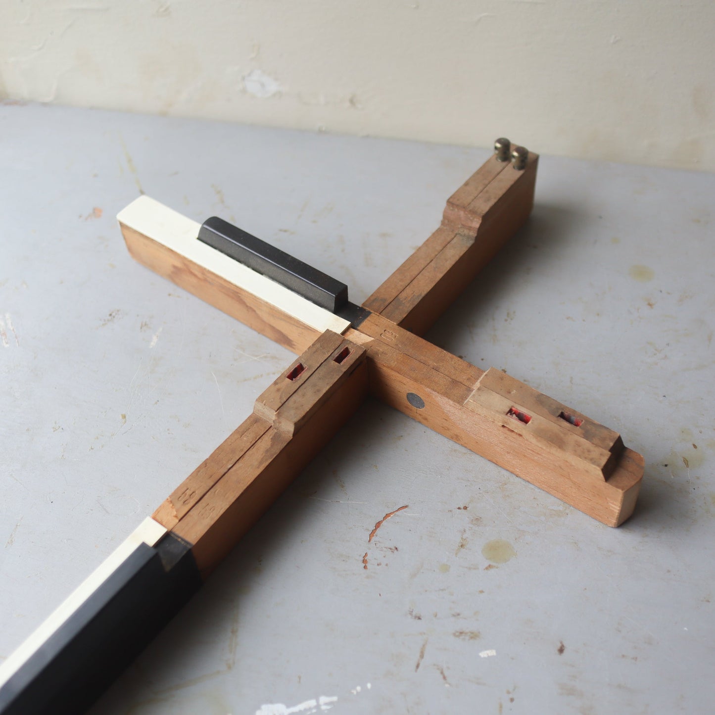 Wooden piano key cross by Dennehey Design Co. featuring a handcrafted design with natural wood finish, ideal for spiritual decor.