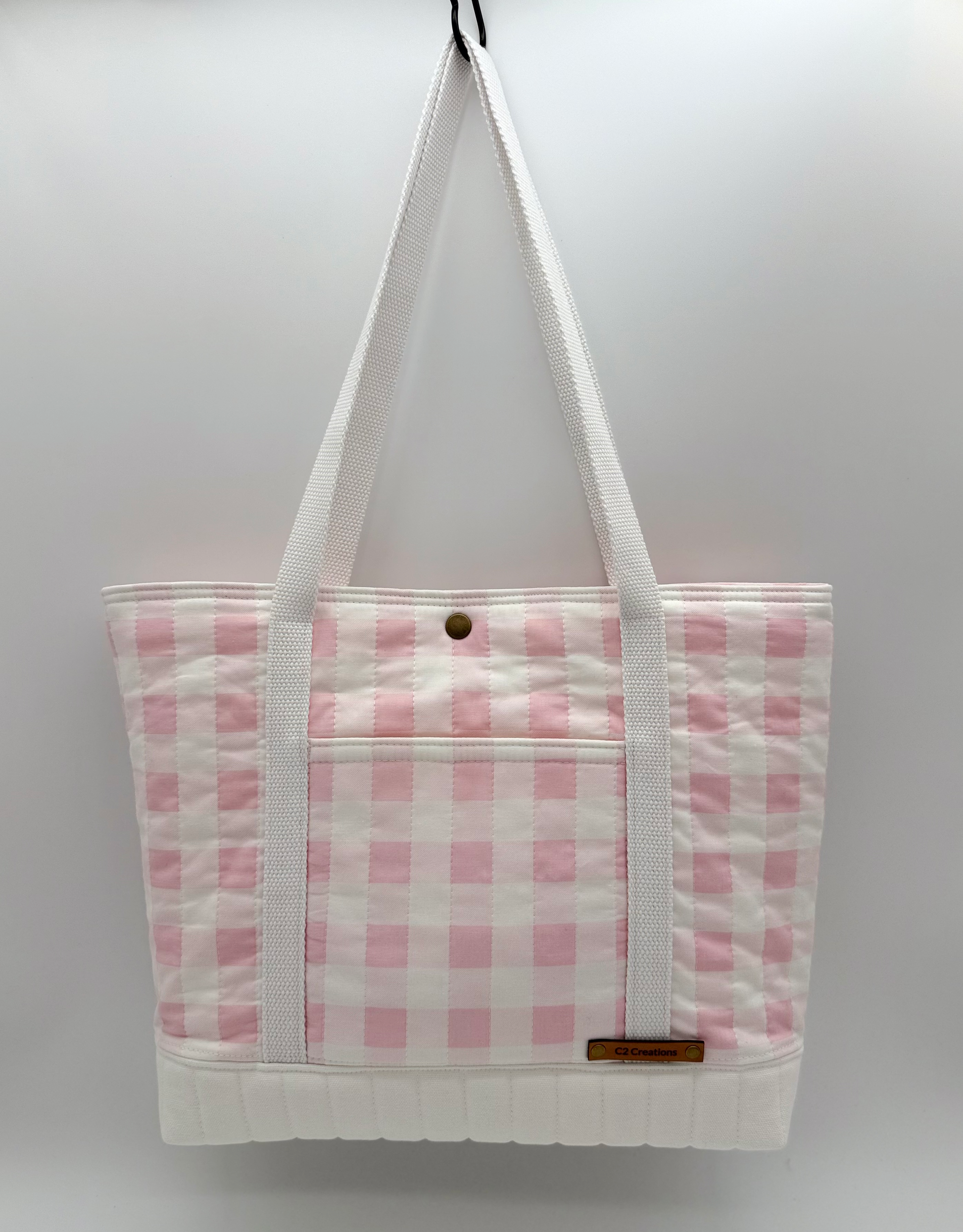 Pink gingham quilted tote bag by C2 Creations LLC, handmade canvas tote with snap closure, front view showing pattern and quilting details.