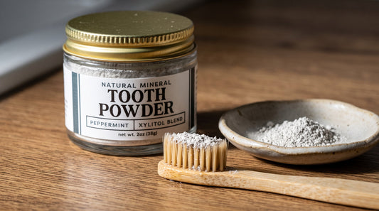 Remineralizing tooth powder by Revive Homestead with hydroxyapatite and xylitol in a natural white container.