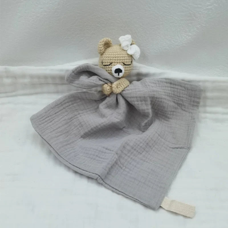 Baby bib with sleeping animal design and attached rattle by Petite Pioneers, featuring soft fabric and playful animal illustrations.