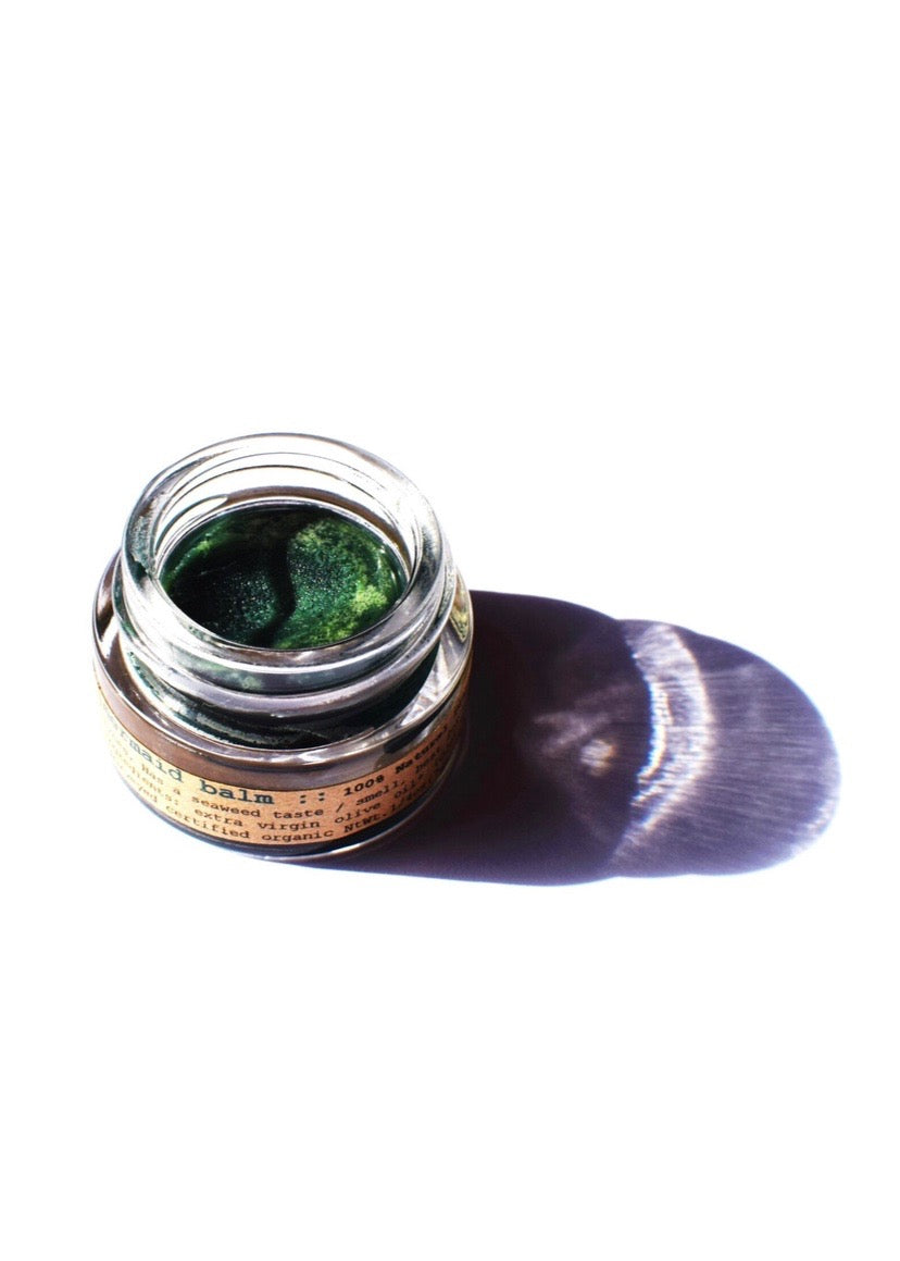 Plant Makeup Mermaid Makeup Balm in a compact container with a shimmering, iridescent finish, showcasing its mermaid-inspired design.