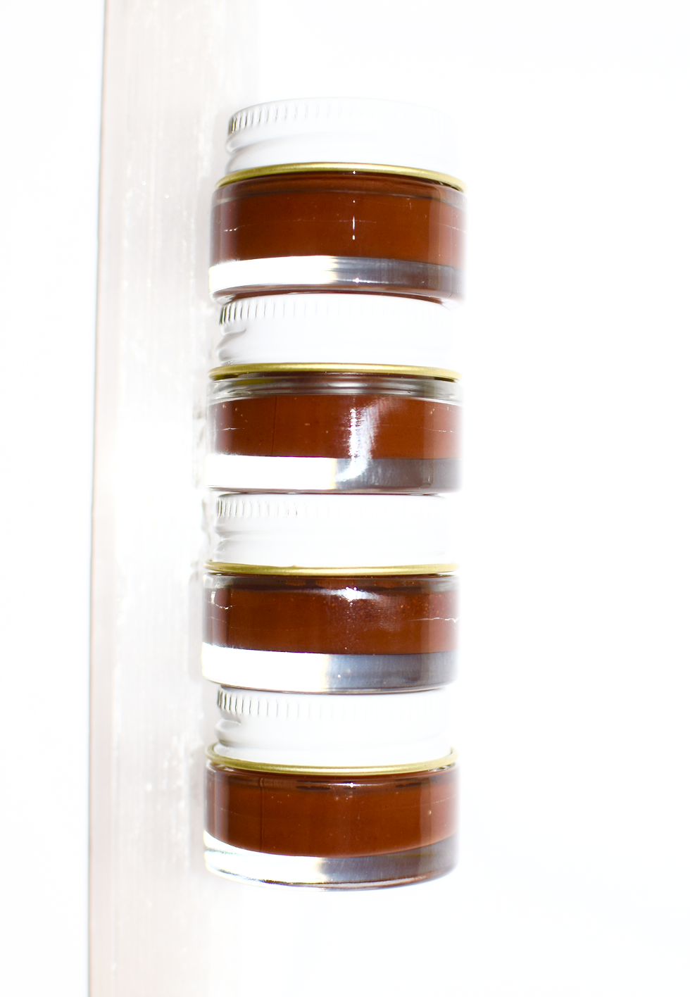 Close-up of plant makeup Cocoa Lip Gloss tube showing the product label and packaging details.
