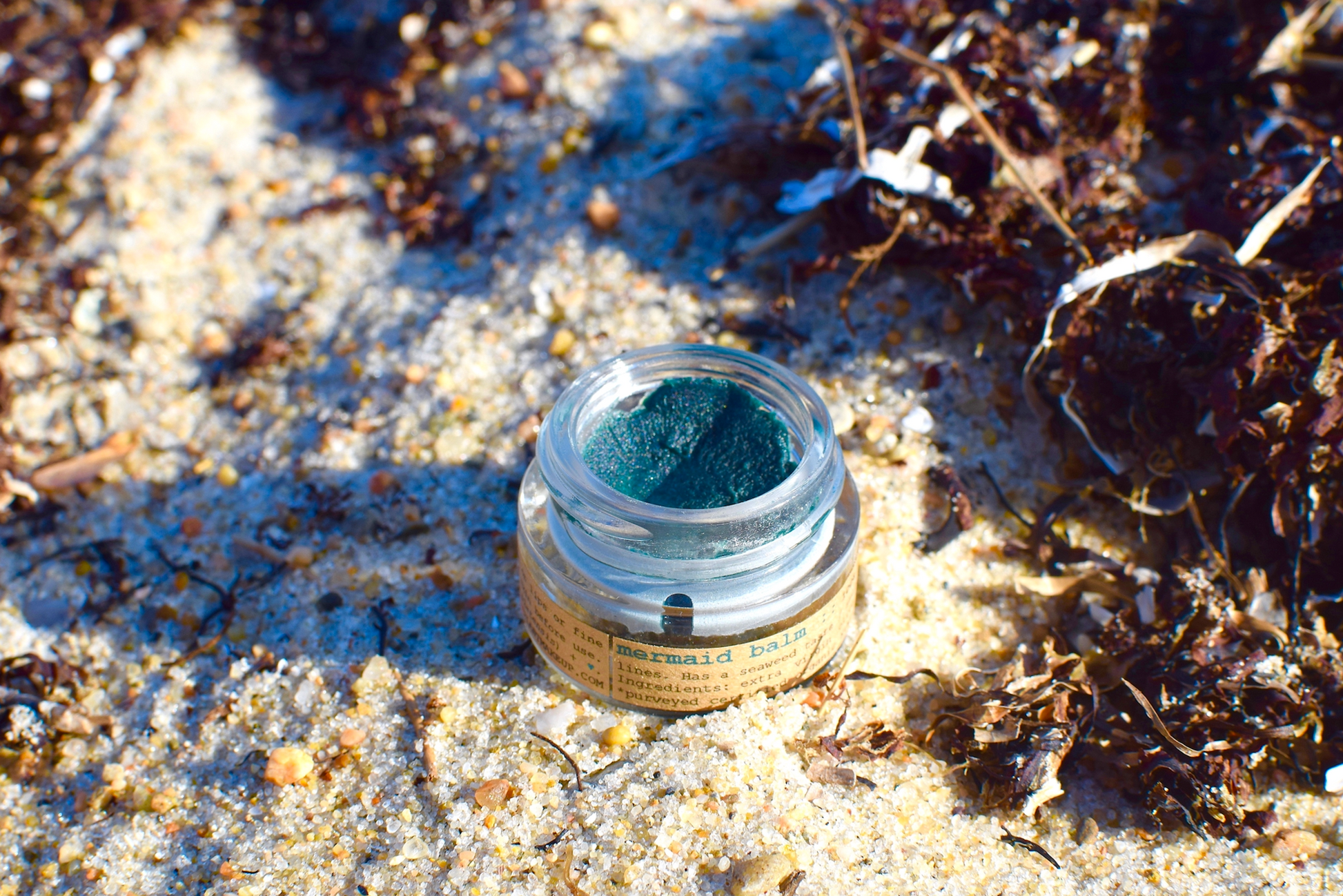 Plant Makeup Mermaid Makeup Balm in a round container with a shimmering, iridescent finish, showcasing the colorful, mermaid-inspired packaging.