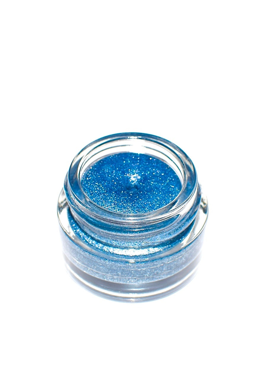 Space Goth Gloss by plant makeup with a shiny, dark purple lip gloss applicator displayed on a mirror surface.