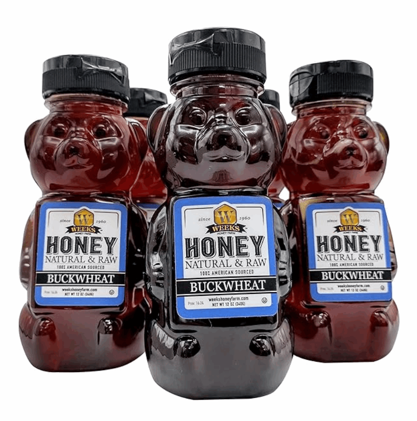 Five bear-shaped bottles of Weeks Raw Buckwheat Honey by Weeks Honey Farm, each with a black cap and blue label, offer antioxidant-rich, pure honey with a robust molasses flavor—perfect for coffee, waffles, or BBQ sauce.