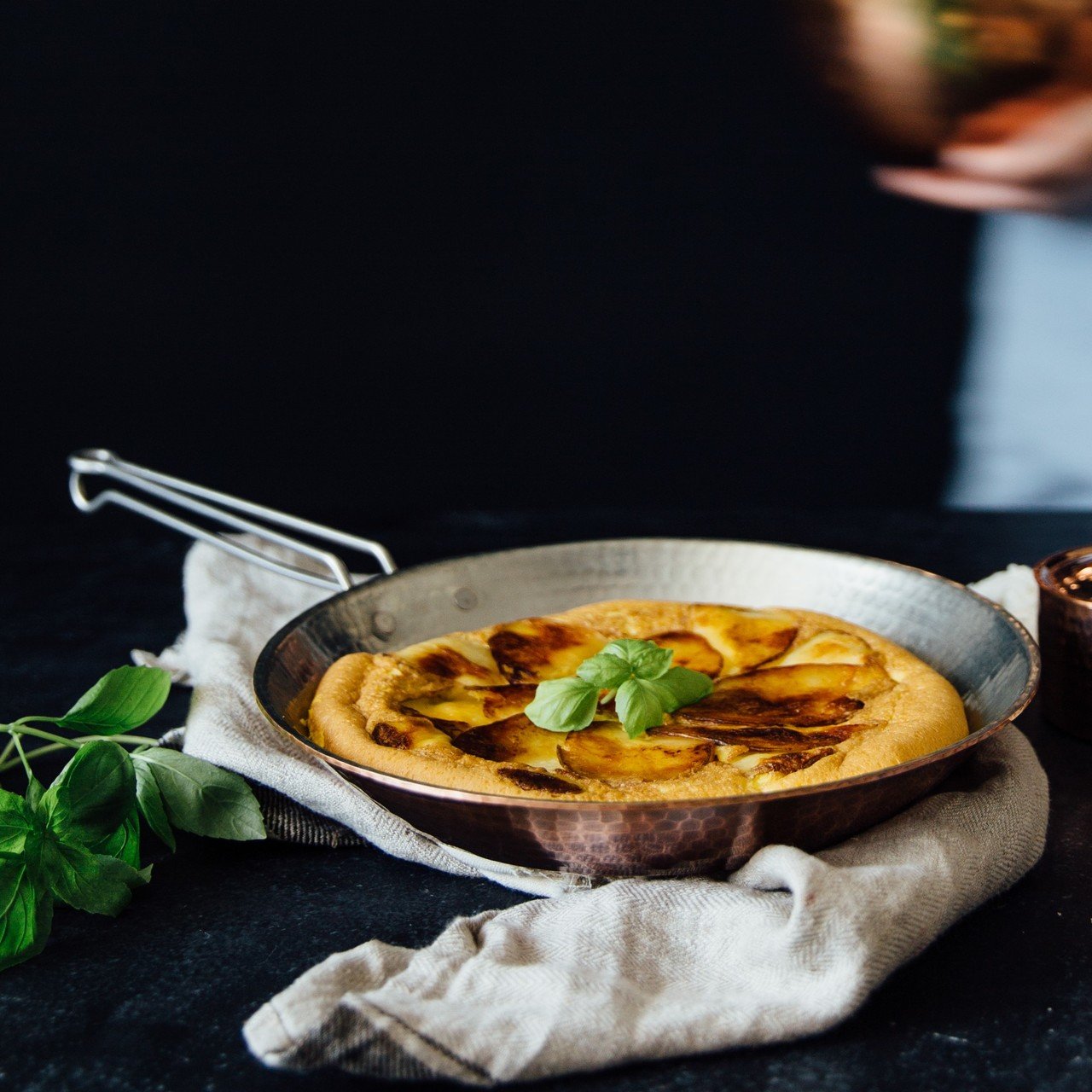 Sertodo copper skillet from a set of pots and pans, showcasing its shiny, handcrafted copper surface and sturdy handle.