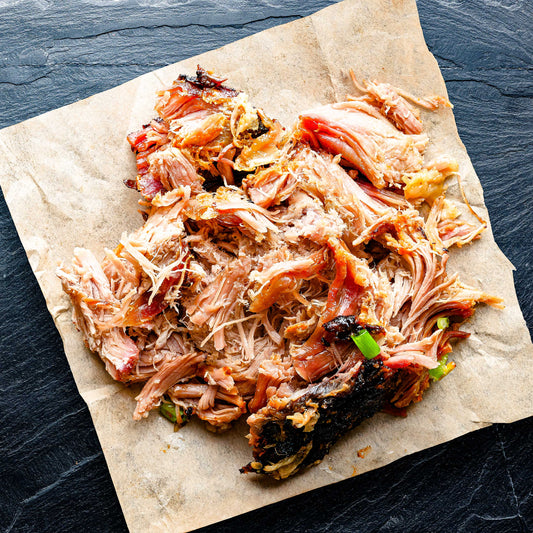 Smoked BBQ pulled chicken from Pig of the Month BBQ, showcasing tender, flavorful smoked meat ready for serving.