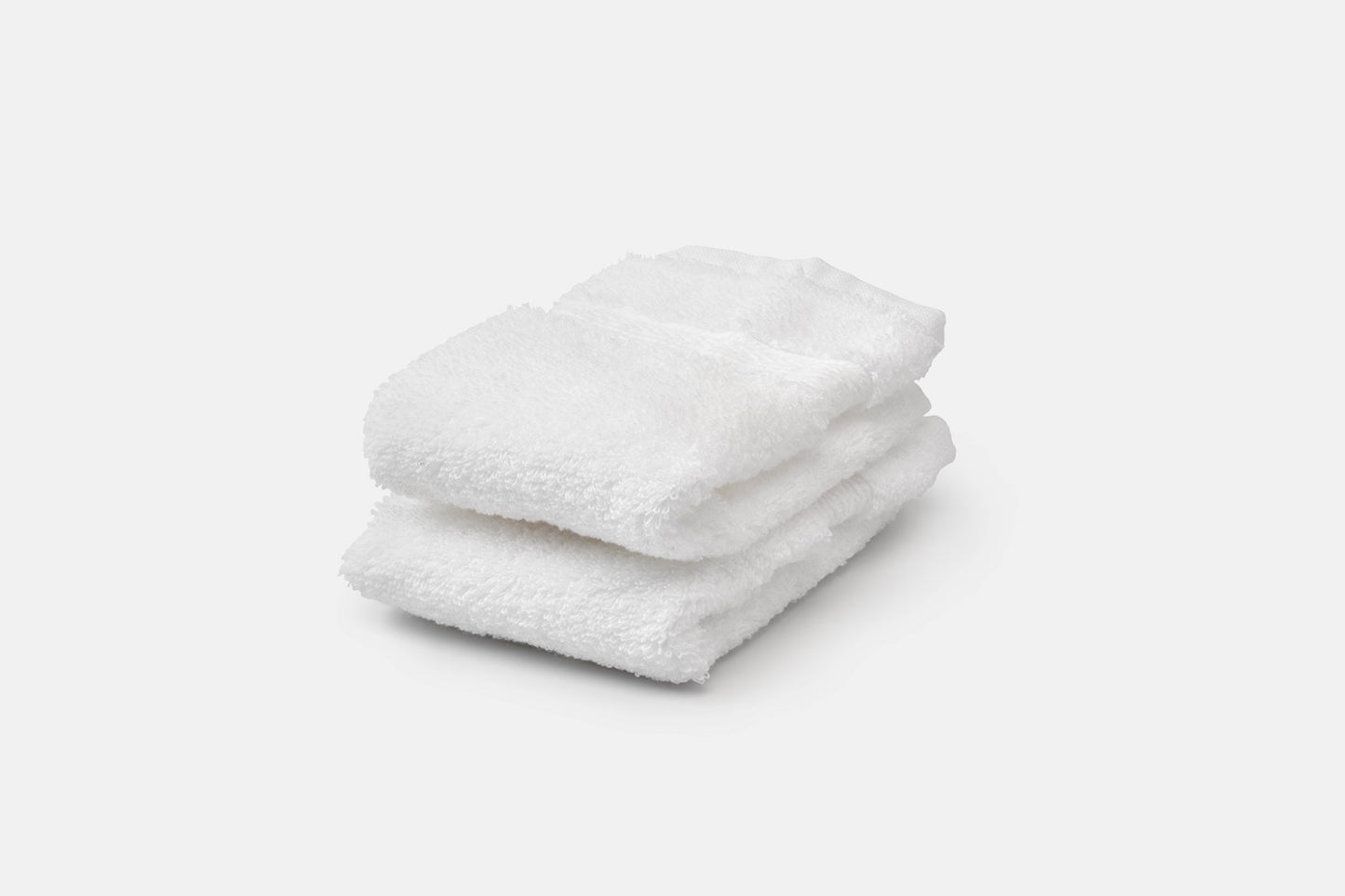Stack of white luxury USA cotton bath washcloths by American Blossom Linens, soft and natural for bathroom use.