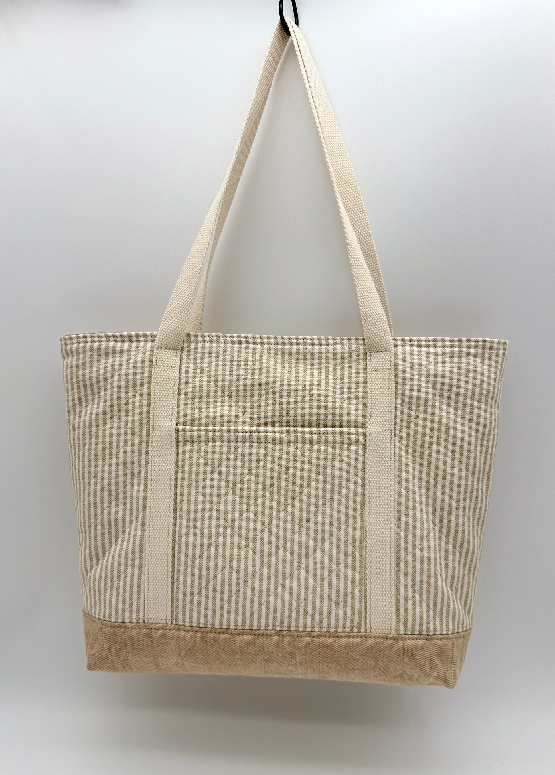 Back view of C2 Creations LLC taupe stripe quilted canvas tote bag with snap closure, showcasing its striped design and handcrafted details.