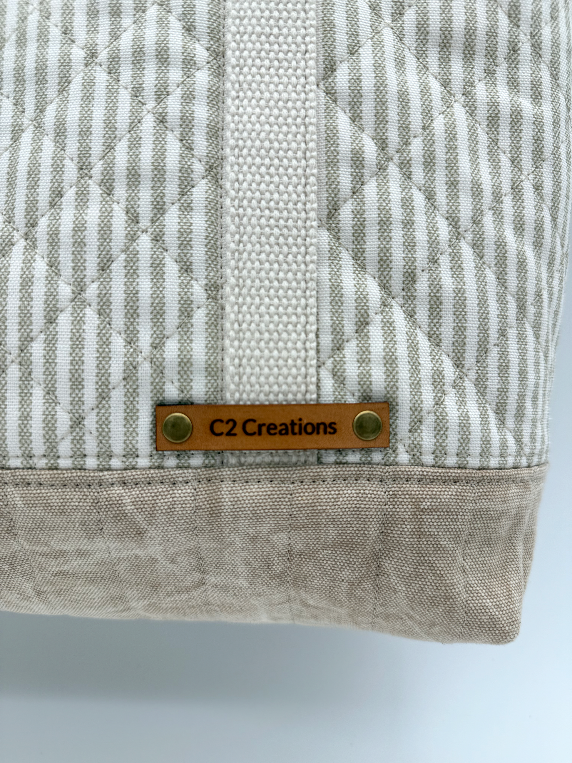 Close-up of taupe striped quilted canvas tote bag with snap closure, handmade by C2 Creations LLC.