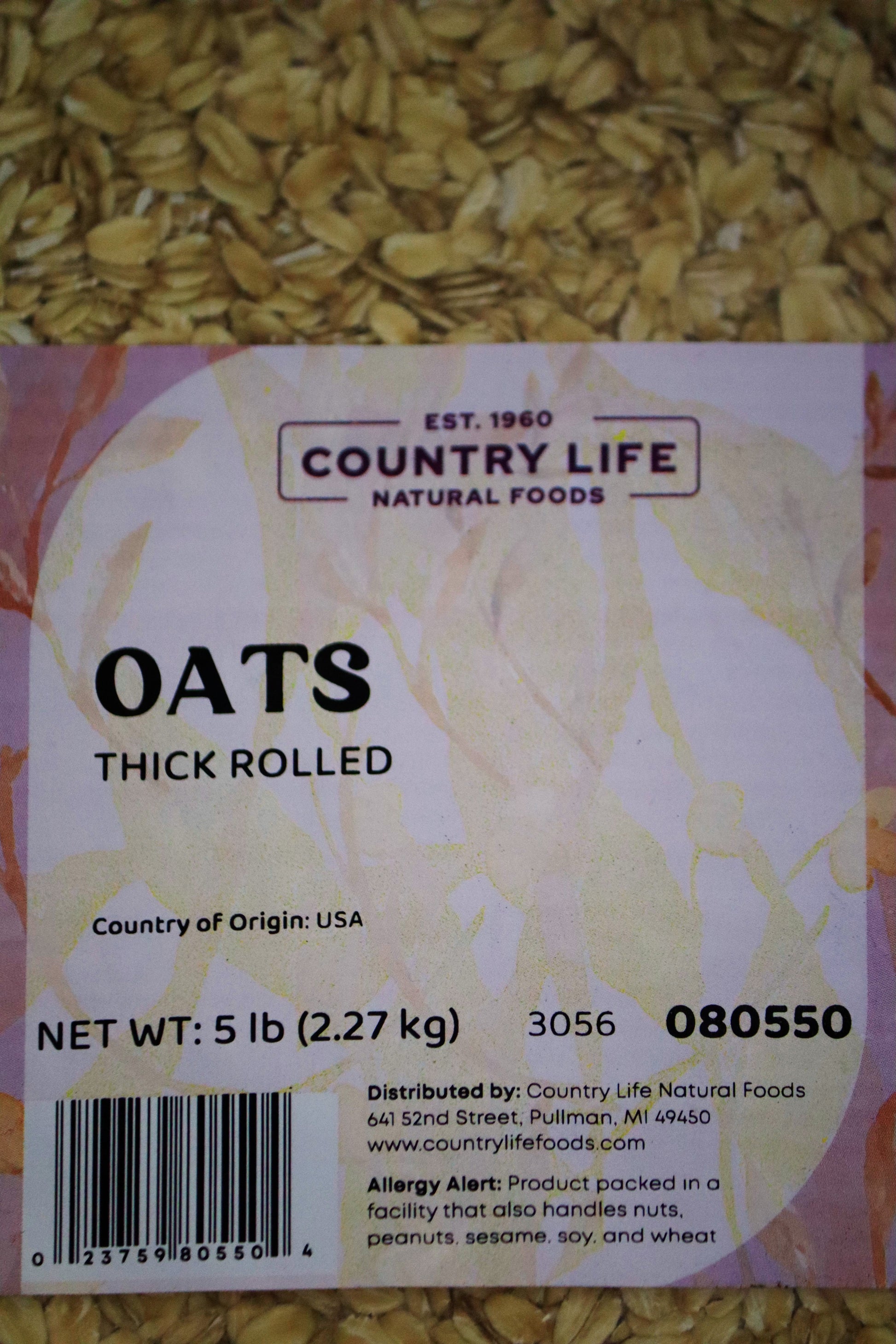 Organic thick rolled oats from Country Life Natural Foods in a clear bowl, showcasing their hearty, textured grain appearance.