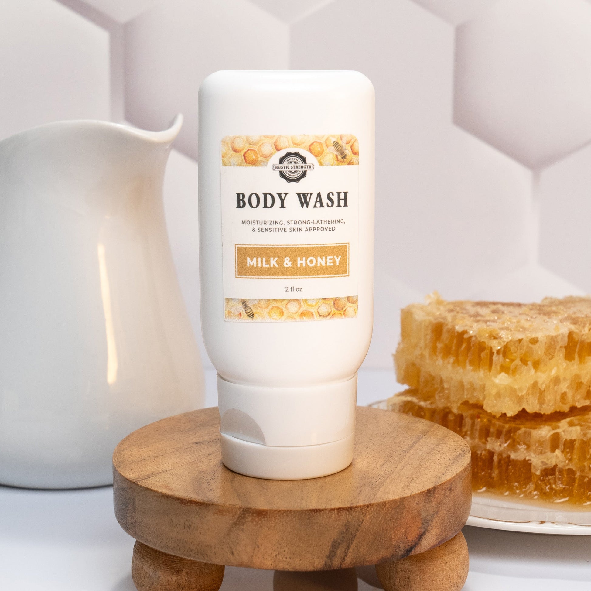 Rustic Strength Milk & Honey travel-sized body wash in a 2 oz bottle, ideal for bath and body care on the go.