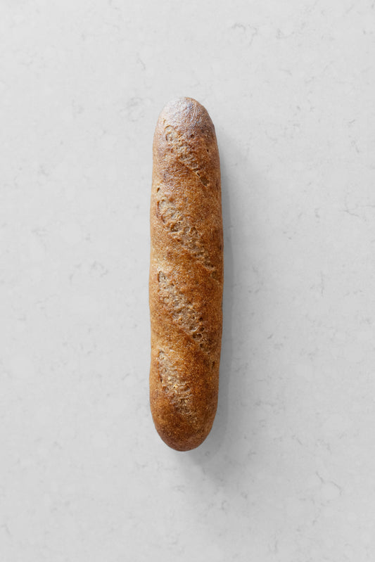 Fresh gluten-free vegan sourdough baguette from Heaven Gluten Free Bakery, showcasing its crusty golden exterior and rustic shape.