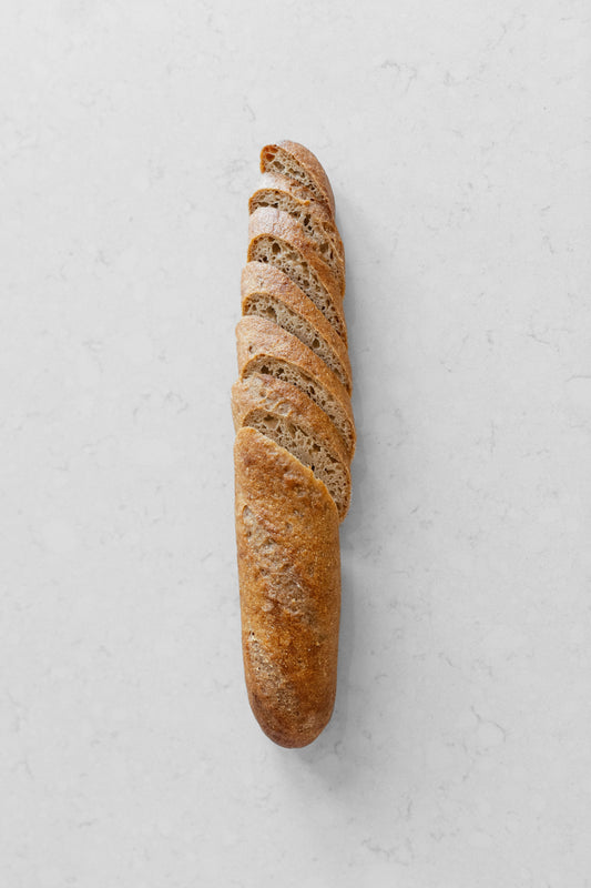 French gluten-free vegan sourdough baguette from Heaven Gluten Free Bakery, showcasing a golden, crusty baguette on a wooden surface.