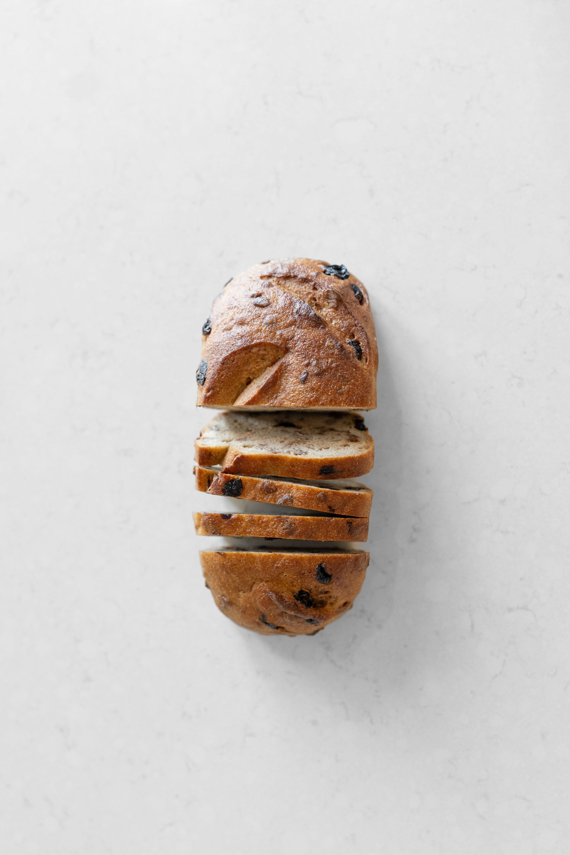 Sliced cranberry and pecan gluten-free vegan sourdough loaf from Heaven Gluten Free Bakery, showing its textured interior and crust.