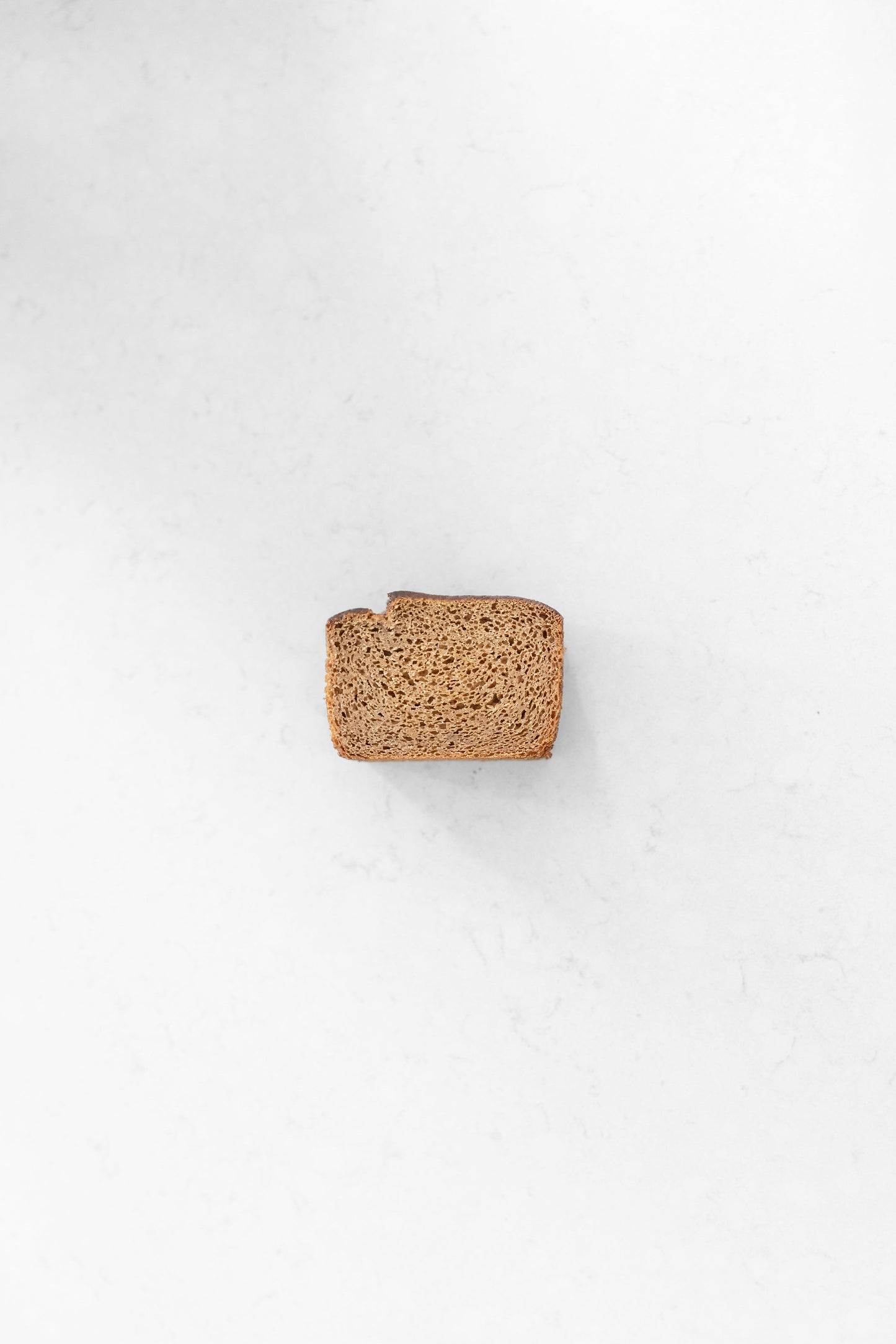 Slice of cinnamon sourdough banana bread from Heaven Gluten Free Bakery, showcasing its moist texture and cinnamon swirl topping.