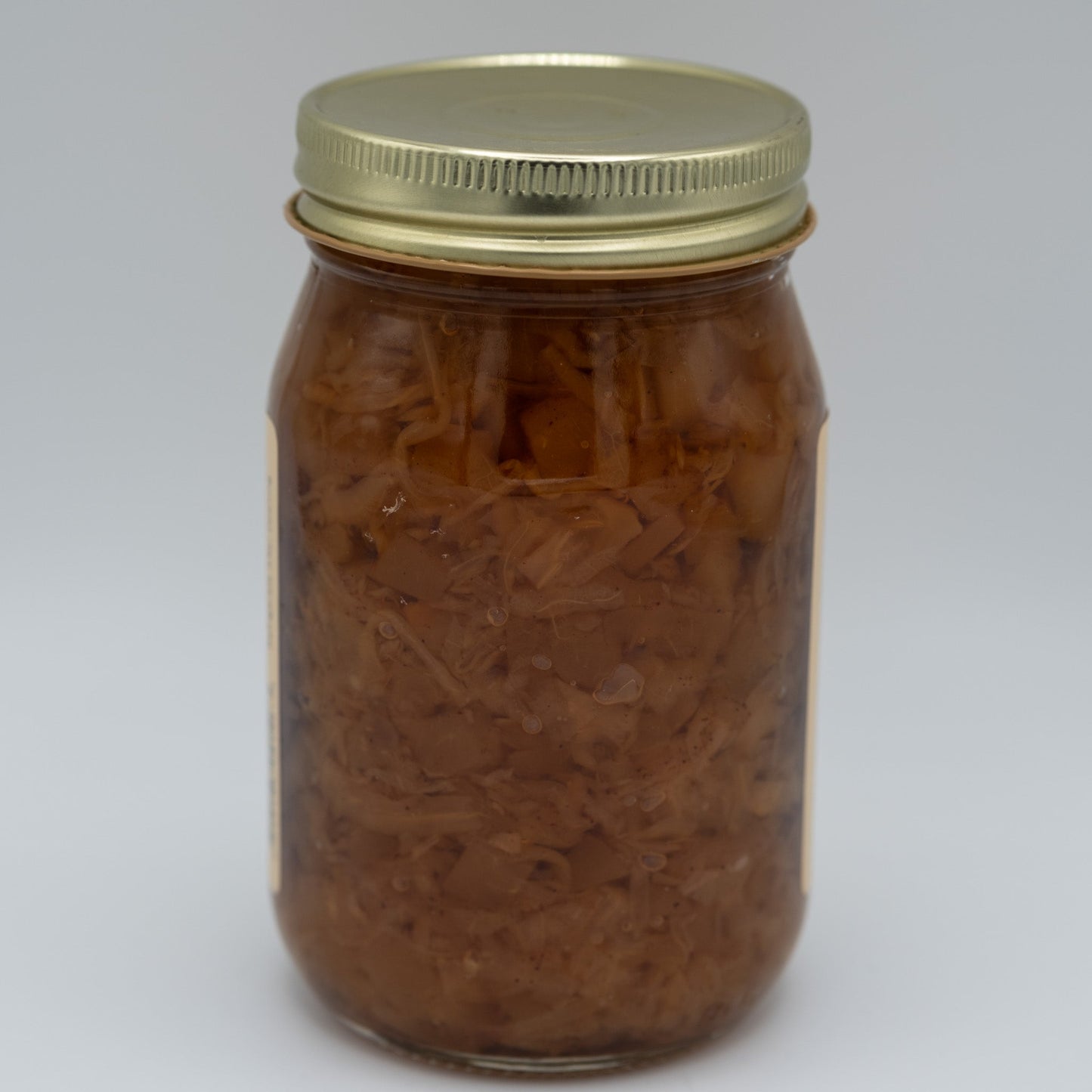 Canned applekraut in a jar, Amish Country Store brand, showing fresh, sliced apples and fermented cabbage inside the product