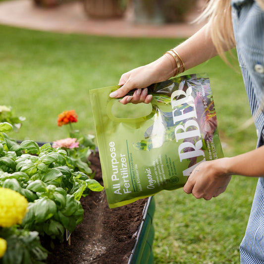 Organic All Purpose Fertilizer by Arber, showing a bag of natural fertilizer with green and white packaging.