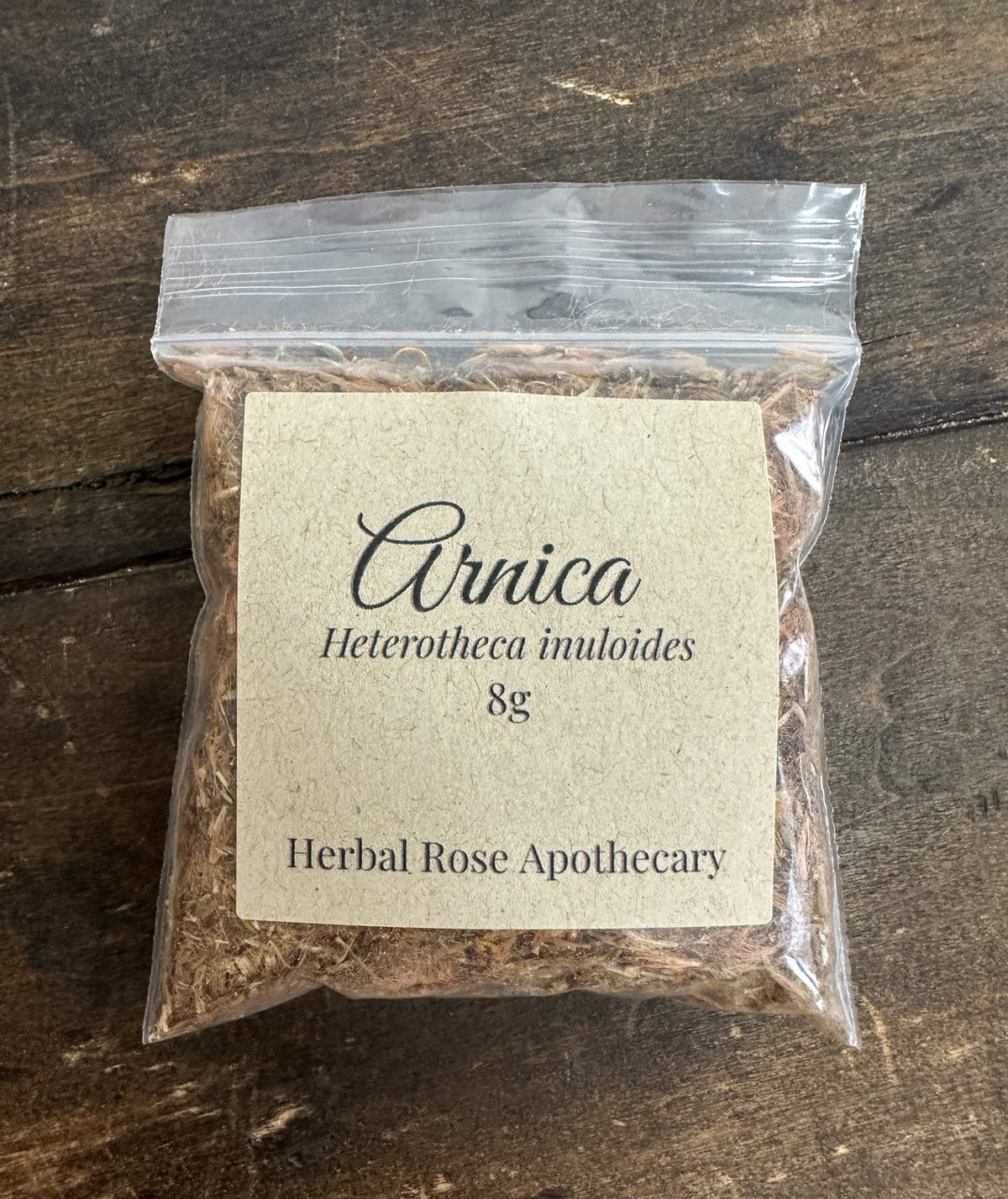 Dried arnica flowers from herbalroseapothecary in an 8g package, showcasing vibrant yellow blooms for herbal remedies.