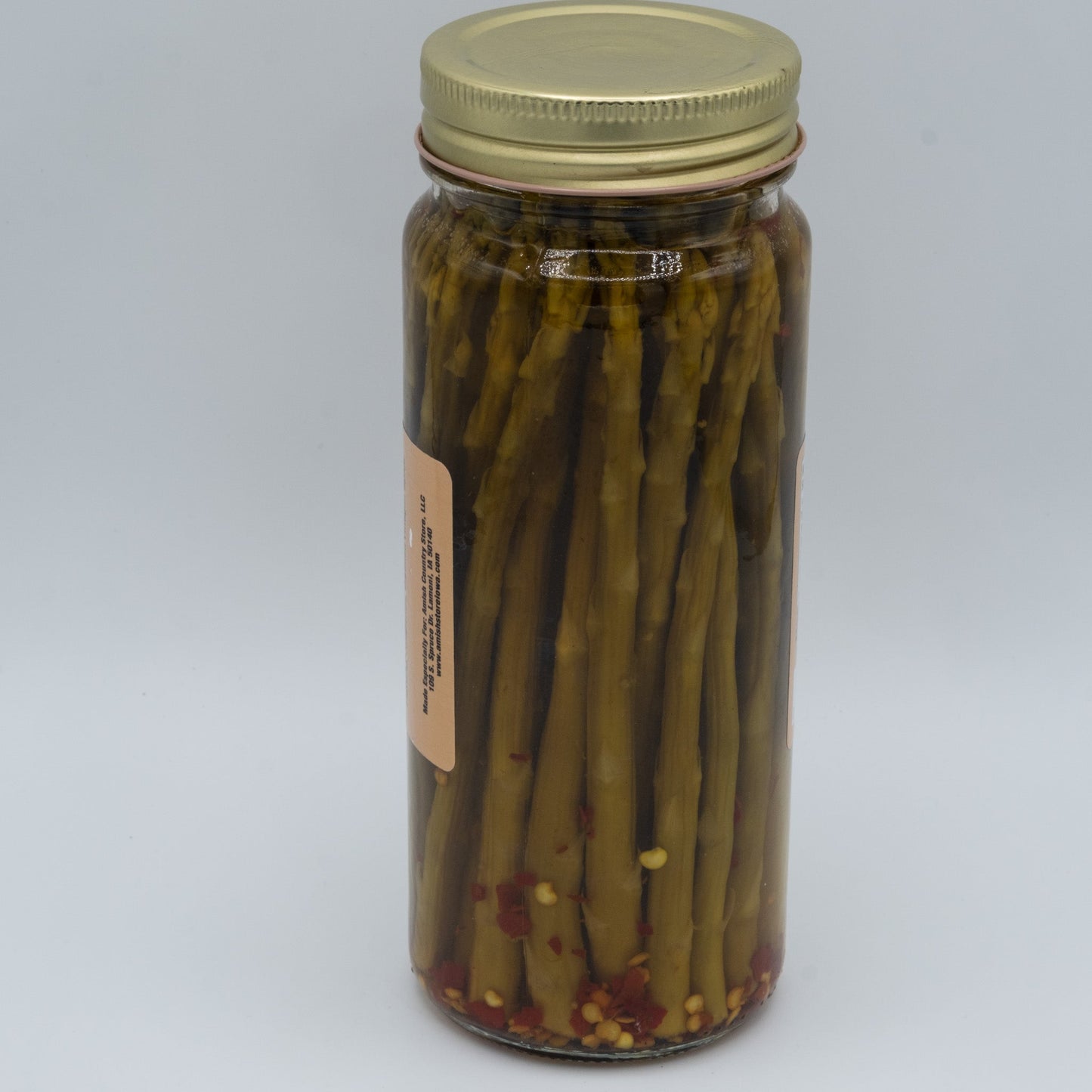 Jar of Amish Country Store hot pickled asparagus in a 16oz glass jar with peppers and spices visible.